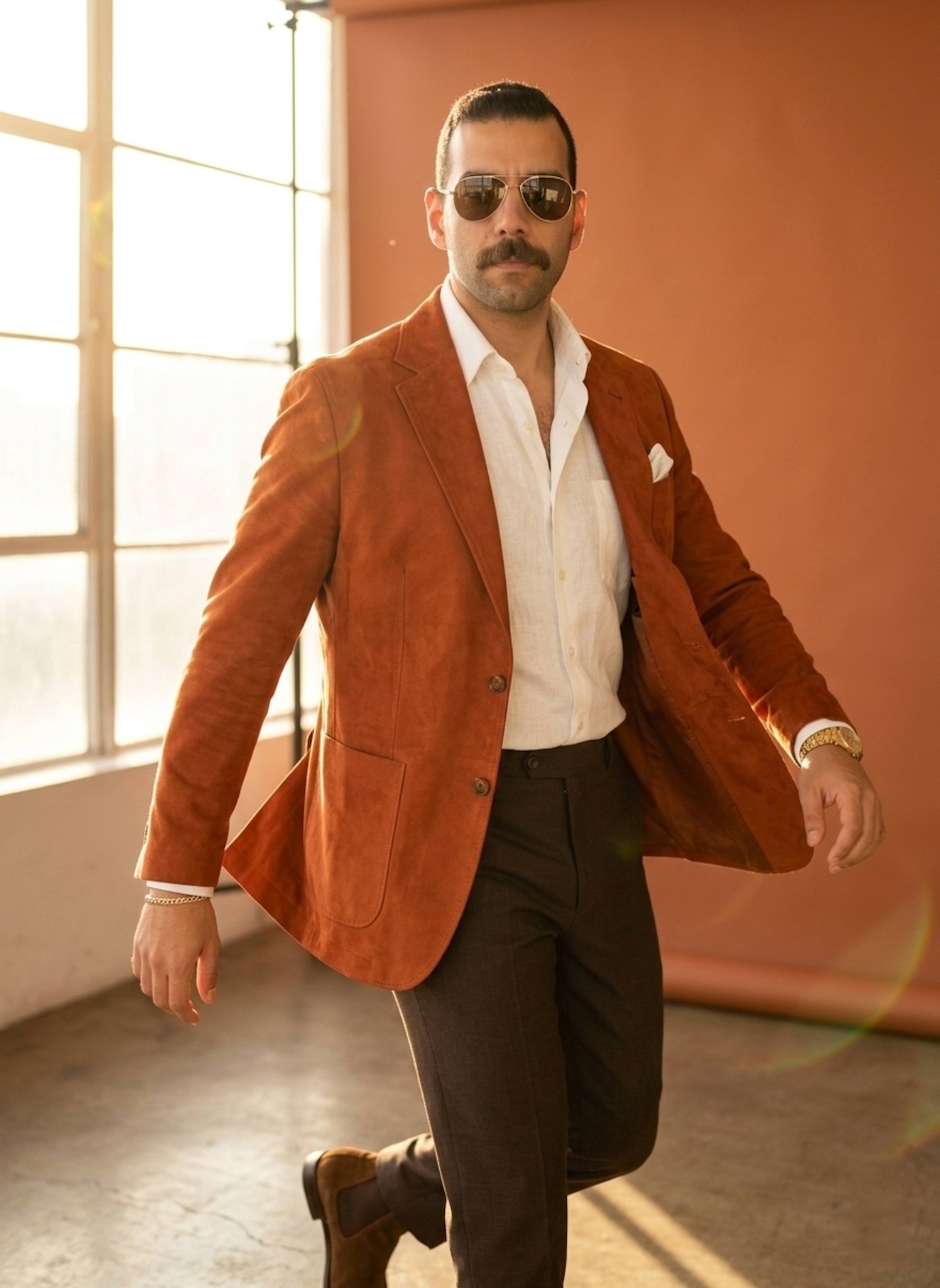 Person mid-turn in rust orange suede blazer with golden afternoon sunlight and lens flares