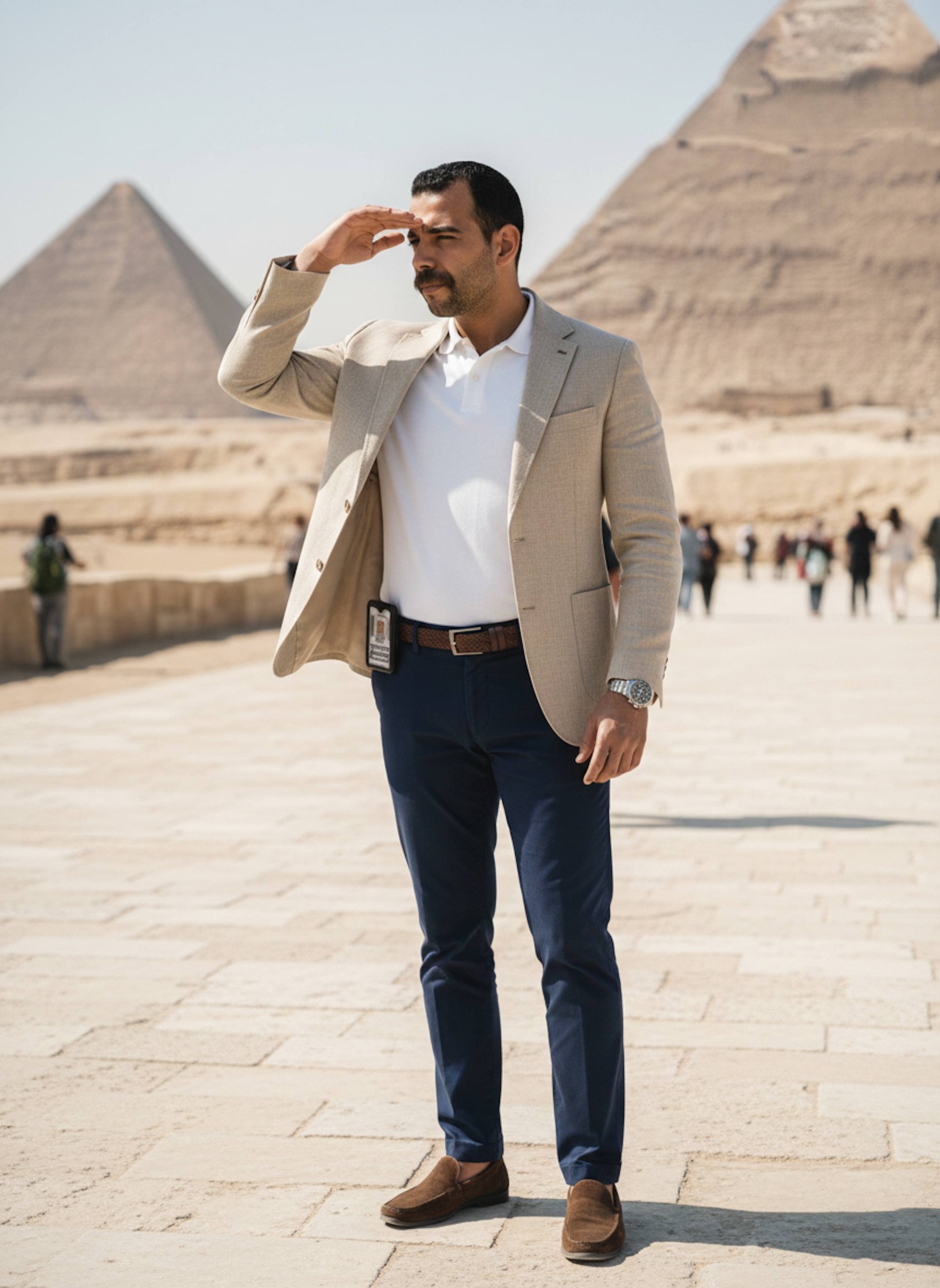 Person in smart casual wear shielding eyes from sun while scanning horizon at Giza pyramid plateau entrance
