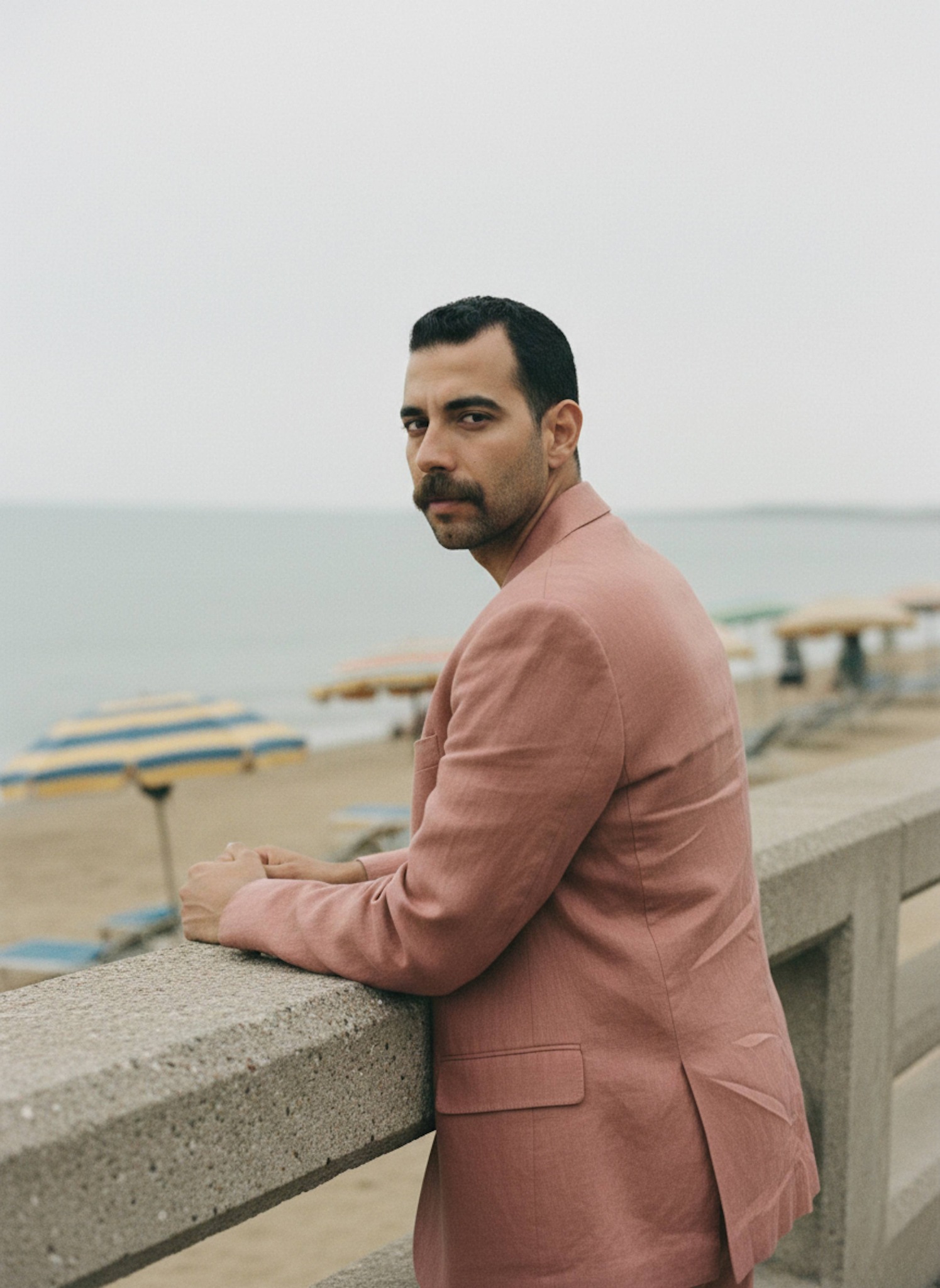Person in a linen suit walking on the Sidi Beshr boardwalk with coastal breeze and warm Mediterranean summer light