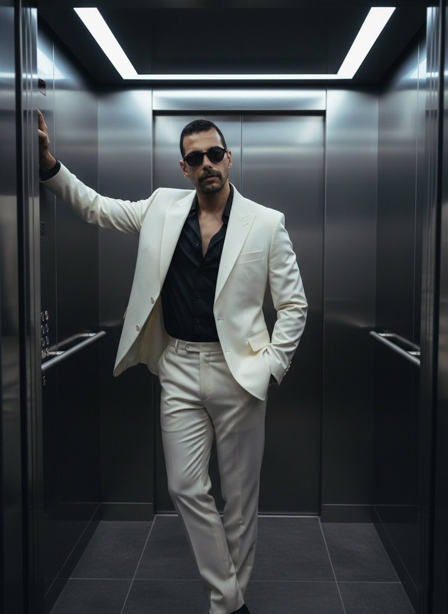 Sophisticated portrait of a person in an off-white suit leaning confidently inside a modern luxury elevator