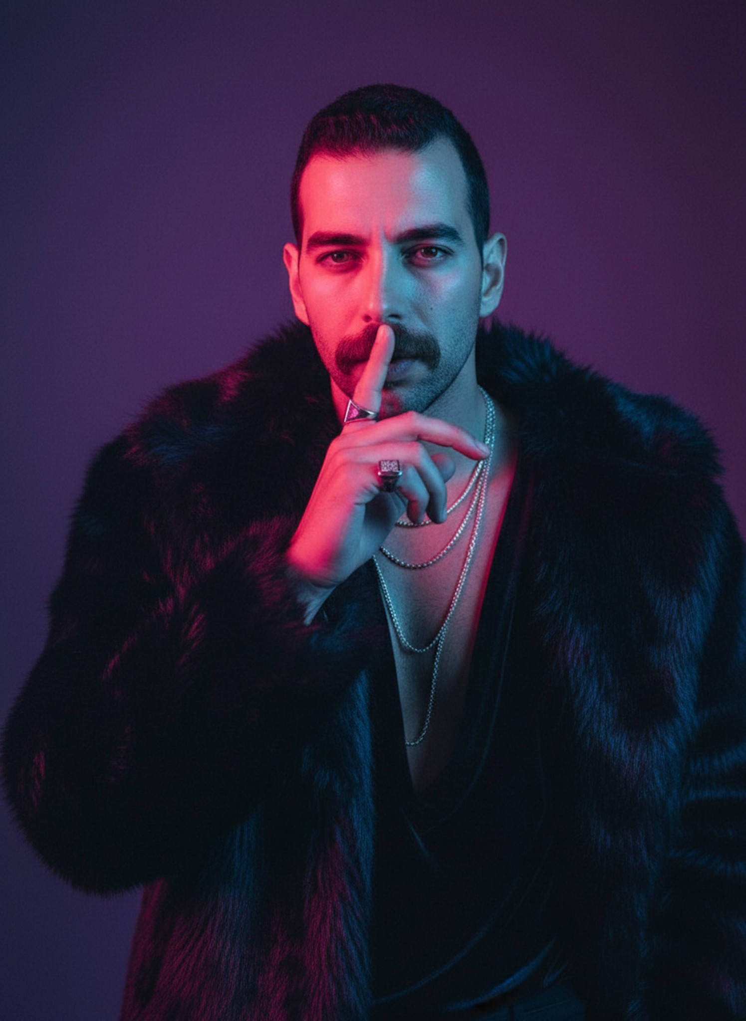 Cinematic studio portrait illuminated by dramatic neon magenta and blue lighting with a black faux fur coat